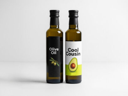 bottle of olive oil standing next to a bottle of avocado oil with the words "cool cousin" on the label.